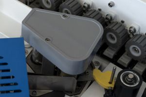 На ней располагается рулон с кромочной лентой диаметром до 50 см, которая подается на обрабатываемое изделие с помощью автоматического устройства.